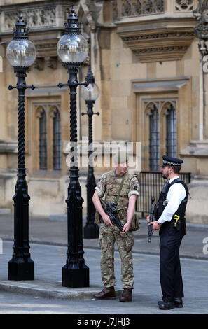Members of the army join police officers outside the Palace of Westminster, London, after Scotland Yard announced armed troops will be deployed to guard 'key locations' such as Buckingham Palace, Downing Street, the Palace of Westminster and embassies. Stock Photo