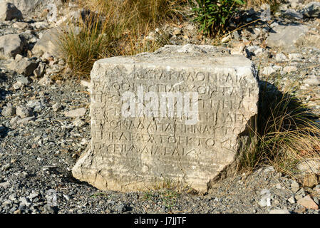 Stone with ancient Greek script. Ruins of temple of Hephaestus on Chimaera Mount. Turkey Stock Photo