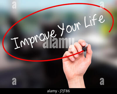 Man Hand writing Improve Your Life with black marker on visual screen. Isolated on background. Business, technology, internet concept. Stock  Photo Stock Photo