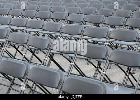 rows of empty chairs - black folding chairs Stock Photo