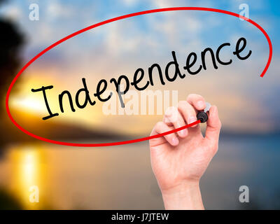 Man Hand writing Independence  with black marker on visual screen. Isolated on background. Business, technology, internet concept. Stock  Photo Stock Photo