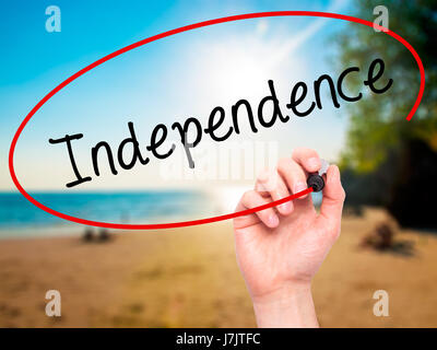 Man Hand writing Independence  with black marker on visual screen. Isolated on background. Business, technology, internet concept. Stock  Photo Stock Photo