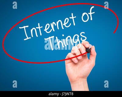 Man Hand writing Internet of Things with black marker on visual screen. Isolated on blue. Business, technology, internet concept. Stock Photo Stock Photo