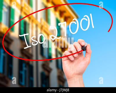 Man Hand writing Iso 27001  with black marker on visual screen. Isolated on city. Business, technology, internet concept. Stock Photo Stock Photo