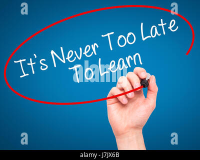 Man Hand writing Its Never Too Late To Learn with black marker on visual screen. Isolated on background. Business, technology, internet concept. Stock Stock Photo