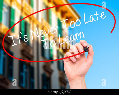 Man Hand writing Its Never Too Late To Learn with black marker on visual screen. Isolated on background. Business, technology, internet concept. Stock Stock Photo