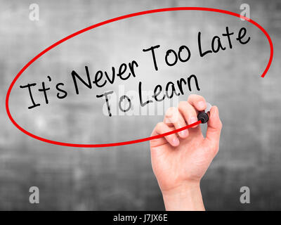 Man Hand writing Its Never Too Late To Learn with black marker on visual screen. Isolated on background. Business, technology, internet concept. Stock Stock Photo