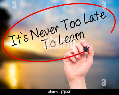 Man Hand writing Its Never Too Late To Learn with black marker on visual screen. Isolated on background. Business, technology, internet concept. Stock Stock Photo