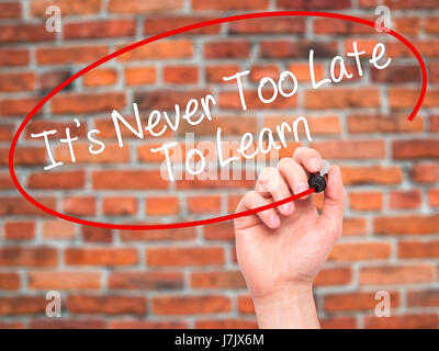 Man Hand writing Its Never Too Late To Learn with black marker on visual screen. Isolated on background. Business, technology, internet concept. Stock Stock Photo