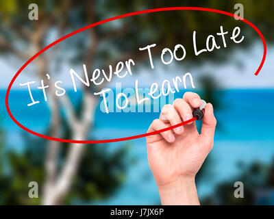 Man Hand writing Its Never Too Late To Learn with black marker on visual screen. Isolated on background. Business, technology, internet concept. Stock Stock Photo