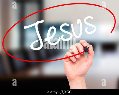 Man Hand writing Jesus  with black marker on visual screen. Isolated on office. Business, technology, internet concept. Stock Photo Stock Photo