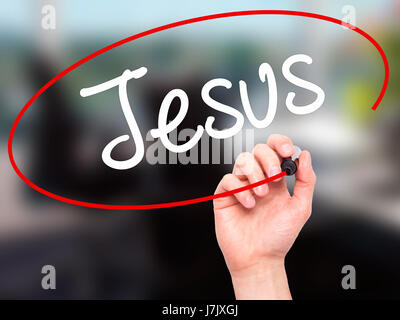 Man Hand writing Jesus  with black marker on visual screen. Isolated on office. Business, technology, internet concept. Stock Photo Stock Photo