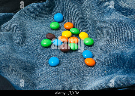 Colorful of chocolate little candies isolated on jeans blue background Stock Photo