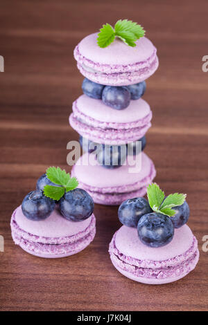 Traditional french macaroons with blueberries on the table Stock Photo