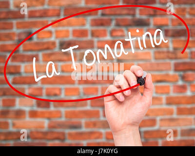 Man Hand writing La Tomatina with black marker on visual screen. Isolated on bricks. Business, technology, internet concept. Stock Photo