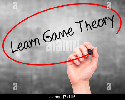 Man Hand writing Learn Game Theory with black marker on visual screen. Isolated on background. Business, technology, internet concept. Stock Photo Stock Photo