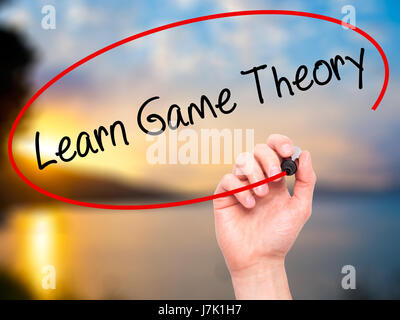 Man Hand writing Learn Game Theory with black marker on visual screen. Isolated on background. Business, technology, internet concept. Stock Photo Stock Photo