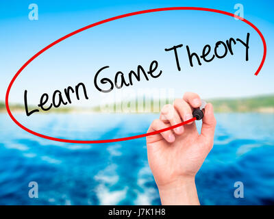 Man Hand writing Learn Game Theory with black marker on visual screen. Isolated on background. Business, technology, internet concept. Stock Photo Stock Photo