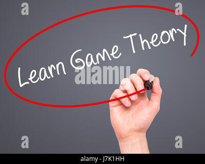 Man Hand writing Learn Game Theory with black marker on visual screen. Isolated on background. Business, technology, internet concept. Stock Photo Stock Photo