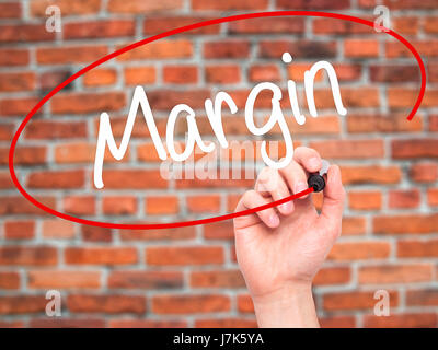 Man Hand writing Margin with black marker on visual screen. Isolated on background. Business, technology, internet concept. Stock Photo Stock Photo