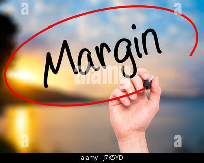 Man Hand writing Margin with black marker on visual screen. Isolated on background. Business, technology, internet concept. Stock Photo Stock Photo