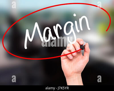 Man Hand writing Margin with black marker on visual screen. Isolated on background. Business, technology, internet concept. Stock Photo Stock Photo