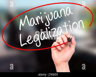 Man Hand writing Marijuana Legalization with black marker on visual screen. Isolated on office. Live, technology, internet concept. Stock Photo Stock Photo