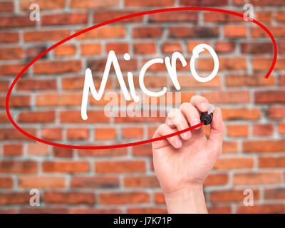 Man Hand writing Micro with black marker on visual screen. Isolated on background. Business, technology, internet concept. Stock Photo Stock Photo