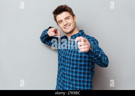 Young cheerful man pointing at camera and choosing you isolated Stock Photo