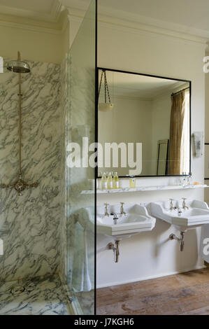 Marble shower unit with large mirror above double basins in Portland Road, London, UK Stock Photo