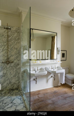 Marble shower unit with large mirror above double basins in Portland Road, London, UK Stock Photo