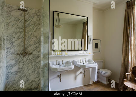 Marble shower unit with large mirror above double basins in Portland Road, London, UK Stock Photo