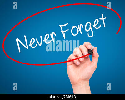 Man Hand writing Never Forget  with black marker on visual screen. Isolated on blue. Business, technology, internet concept. Stock Photo Stock Photo