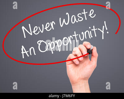 Man Hand writing Never Waste An Opportunity! with black marker on visual screen. Isolated on grey. Business, technology, internet concept. Stock Photo Stock Photo