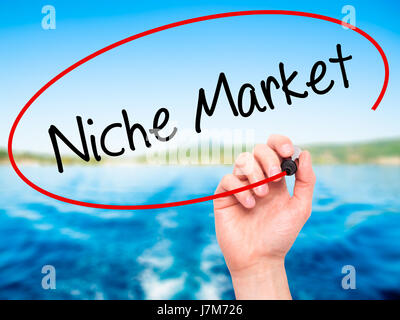 Man Hand writing Niche Market with black marker on visual screen. Isolated on background. Business, technology, internet concept. Stock Photo Stock Photo