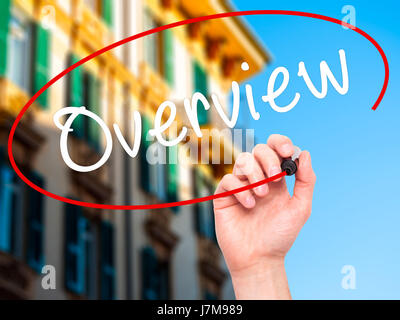 Man Hand writing Overview with black marker on visual screen. Isolated on city. Business, technology, internet concept. Stock Photo Stock Photo