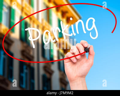 Man Hand writing Parking with black marker on visual screen. Isolated on city. Business, technology, internet concept. Stock Photo Stock Photo