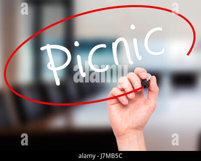 Man Hand writing Picnic with black marker on visual screen. Isolated on office. Business, technology, internet concept. Stock Photo Stock Photo