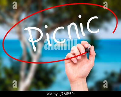 Man Hand writing Picnic with black marker on visual screen. Isolated on nature. Business, technology, internet concept. Stock Photo Stock Photo