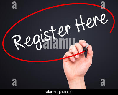 Man Hand writing Register Here with black marker on visual screen. Isolated on black. Business, technology, internet concept. Stock Photo Stock Photo