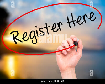 Man Hand writing Register Here with black marker on visual screen. Isolated on nature. Business, technology, internet concept. Stock Photo Stock Photo