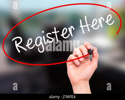 Man Hand writing Register Here with black marker on visual screen. Isolated on office. Business, technology, internet concept. Stock Photo Stock Photo