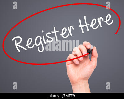 Man Hand writing Register Here with black marker on visual screen. Isolated on grey. Business, technology, internet concept. Stock Photo Stock Photo