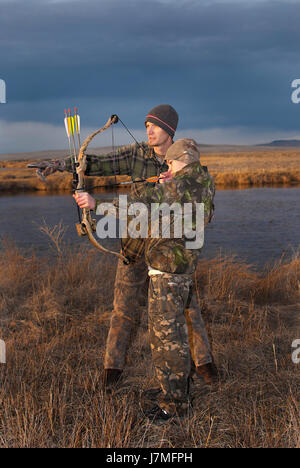 Young boy learns to hunt from dad Stock Photo