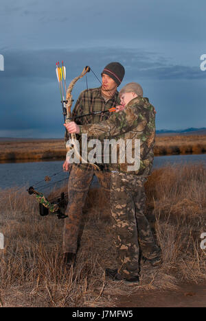 Young boy learns to hunt from dad Stock Photo