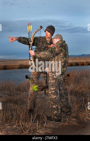 Young boy learns to hunt from dad Stock Photo