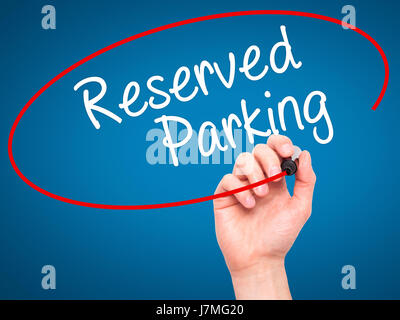 Man Hand writing Reserved Parking with black marker on visual screen. Isolated on blue. Business, technology, internet concept. Stock Photo Stock Photo