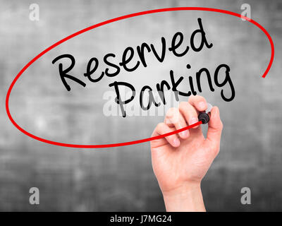 Man Hand writing Reserved Parking with black marker on visual screen. Isolated on grey. Business, technology, internet concept. Stock Photo Stock Photo