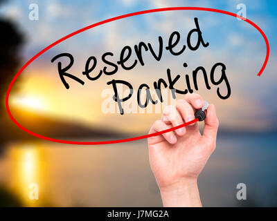 Man Hand writing Reserved Parking with black marker on visual screen. Isolated on nature. Business, technology, internet concept. Stock Photo Stock Photo