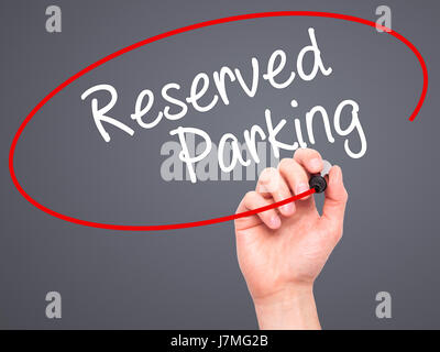 Man Hand writing Reserved Parking with black marker on visual screen. Isolated on grey. Business, technology, internet concept. Stock Photo Stock Photo